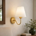 Gold Curved Arm Wall Sconce with Fabric Shade — in an interior setting