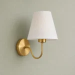 Gold Curved Arm Wall Sconce with Fabric Shade — complete fixture in an interior setting
